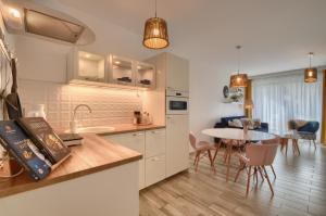 a kitchen and dining room with a table and chairs at Mountain Szczyrk ApArt Bratków 10A in Szczyrk