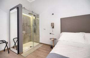 una camera con una doccia in vetro e un letto di Clementi 18 Suites Rome a Roma