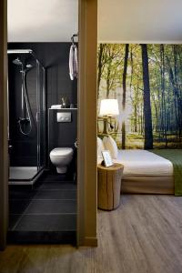 a bedroom with a bed and a shower and a toilet at Hotel Zuid in Genk