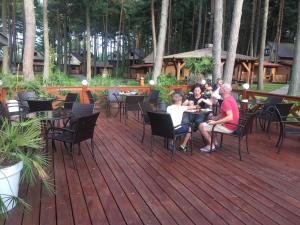 a group of people sitting at a table on a deck at Blue Resort Ostrowo in Ostrowo