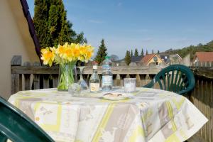 a table with a vase of flowers and bottles of water at Ferienhaus "Steffan" in Trassenheide