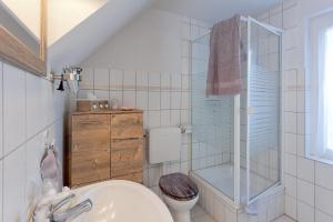 a white bathroom with a toilet and a sink at Ferienhaus "Steffan" in Trassenheide +12 photos