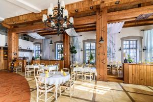 a dining room with white tables and chairs at Malom Hotel in Debrecen
