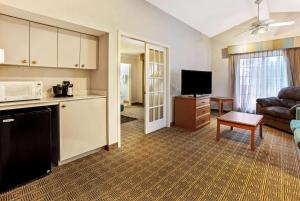 a kitchen and a living room with a couch and a microwave at La Quinta Inn by Wyndham College Station in College Station