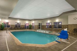 a large pool in a hotel with a blue chair at La Quinta Inn & Suites by Wyndham Loveland Estes Park in Loveland