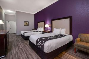 a hotel room with two beds and a purple wall at La Quinta Inn & Suites by Wyndham Loveland Estes Park in Loveland