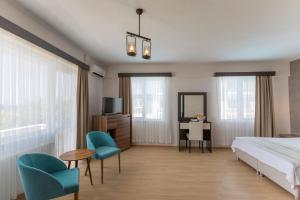 ein Hotelzimmer mit Bett, Stühlen und Schreibtisch in der Unterkunft Troas Beach Hotel in Tavaklı + 93 Fotos
