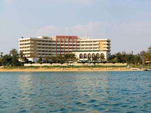 un grande edificio sulla spiaggia con l'acqua di Mercure Ismailia Forsan Island a Ismailia
