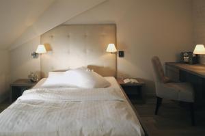 a bedroom with a bed and a desk and a chair at Bad Bubendorf Design & Lifestyle Hotel in Bubendorf