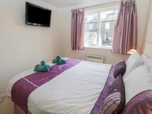 una camera da letto con un letto con due peluche sopra di Cumbria Court a Windermere