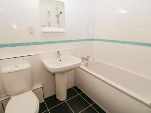 a bathroom with a toilet and a sink and a tub at Cumbria Court in Windermere