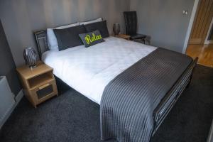 a bedroom with a large bed and a night stand at Pullman House in Darlington