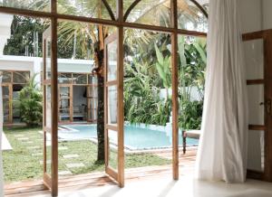 a room with a view of a pool through a glass door at The Oasis Villa in Ahangama