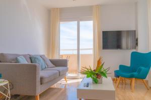 sala de estar con sofá gris y silla azul en Lovely Apartment Beach Front & Pool, en El Campello