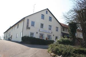 ein großes weißes Gebäude an der Straßenseite in der Unterkunft Hotel Berg in Höchstädt an der Donau