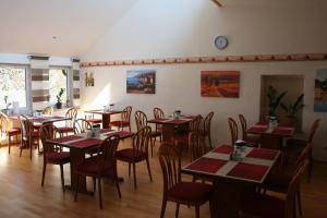 un comedor con mesas y sillas y un reloj en la pared en Gasthof Berg, en Höchstädt an der Donau