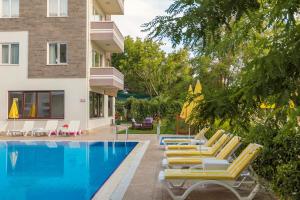 ein Pool mit Liegestühlen neben einem Gebäude in der Unterkunft Troas Beach Hotel in Tavaklı