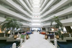 a lobby with chairs and plants in a building at Sheraton Okinawa Sunmarina Resort in Onna
