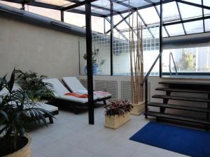 einen Balkon mit weißen Möbeln und Pflanzen in einem Gebäude in der Unterkunft Long Beach - casi un spa in Punta del Este