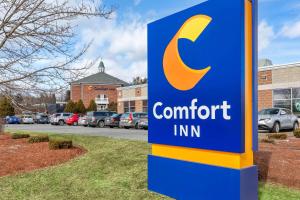 una señal para una posada de confort frente a un aparcamiento en Comfort Inn Auburn-Worcester en Auburn