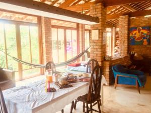 a dining room with a table and chairs and windows at Toca da Capuava in Cotia