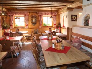 a restaurant with tables and chairs and windows at Hotel Almhof in Neustift im Stubaital