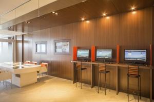 a room with three monitors and a table with chairs at Sheraton Okinawa Sunmarina Resort in Onna