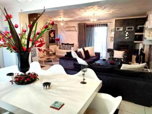 a living room with a white table with flowers on it at Greek hospitality in Athens