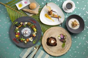 a table with plates of food and a cup of coffee at Sheraton Okinawa Sunmarina Resort in Onna