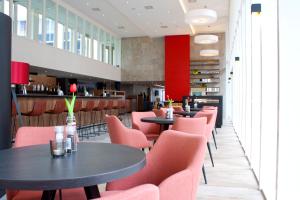 un restaurant avec des tables et des chaises ainsi qu'un bar dans l'établissement Bastion Hotel Arnhem, à Arnhem