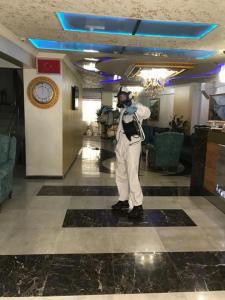 a man standing in a lobby with a clock at Hotel Grand Heykel in Bursa
