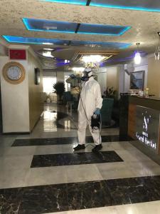 Ein Mann steht in einer Lobby in einem Hotel. in der Unterkunft Hotel Grand Heykel in Bursa