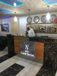 a restaurant with clocks on the wall and a counter at Hotel Grand Heykel in Bursa