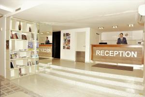 a person standing at a reception desk in a lobby at Akcent hotel in Prague