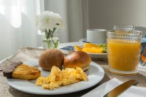 a table with a plate of food and a glass of orange juice at Aqua - Pópulo Eco Village in Ponta Delgada