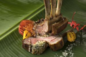 a piece of meat with a fork on a green leaf at Sheraton Okinawa Sunmarina Resort in Onna