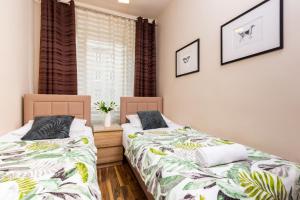 two beds sitting next to each other in a bedroom at Apartments Warsaw Hoża by Renters in Warsaw