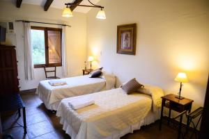 a hotel room with two beds and a window at Hosteria La Caldera in La Caldera
