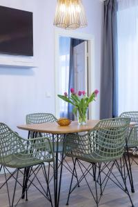 Südalinna apartment في كوريساري: طاولة طعام مع كراسي و إناء من الزهور