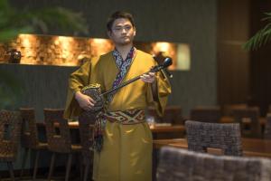 a man is holding a sword in a room at Sheraton Okinawa Sunmarina Resort in Onna