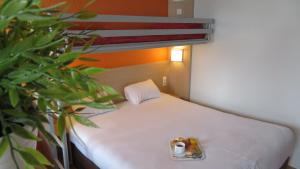 ChaintréにあるPremière Classe Mâcon Sudの小さなベッド1台が備わる小さな客室です。