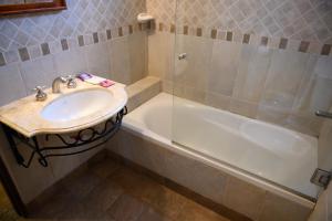 a bathroom with a sink and a bath tub at Hosteria La Caldera in La Caldera +109 photos