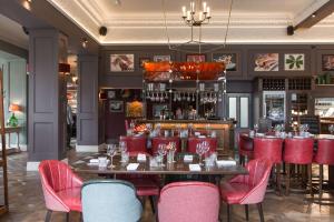 a restaurant with a table and red chairs at The Park Hotel in Teddington