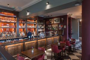 a bar in a restaurant with tables and chairs at The Park Hotel in Teddington