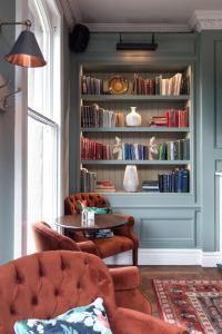 a living room with a book shelf with books at The Park Hotel in Teddington