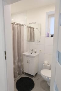 a white bathroom with a sink and a toilet at Stadtzimmer in Salzhemmendorf