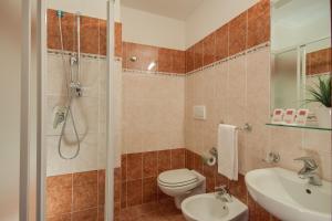 uma casa de banho com um WC, um chuveiro e um lavatório. em Hotel RomAntica em Roma