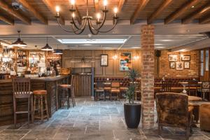 a restaurant with a bar with chairs and tables at The Bridge Hotel in Chertsey