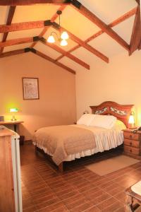 una camera con letto in una stanza con soffitti in legno di Hotel Boutique La Posada a Sucre