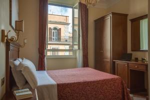 a bedroom with a bed and a large window at Hotel RomAntica in Rome
